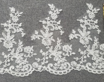 May include: White lace trim with a floral design. The lace is approximately 2 inches wide.