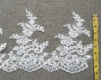 May include: White lace trim with a floral design. The lace is approximately 7 inches wide.