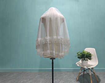 May include: A white bridal veil with a double layer of fringe trim. The veil is displayed on a mannequin against a light blue background.