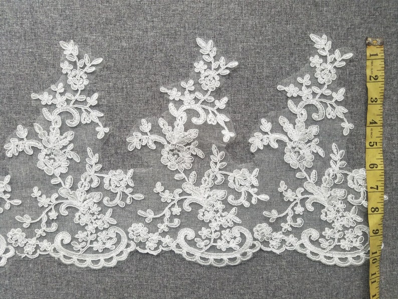 May include: White lace trim with a floral design. The lace is about 2 inches wide.