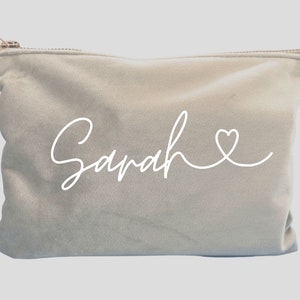May include: A light gray velvet zippered pouch with the name "Sarah" written in white cursive script with a small heart at the end.