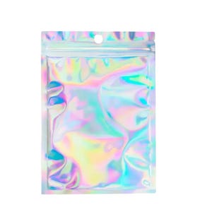 May include: A small, rectangular holographic mylar bag with a zip closure and a small hole at the top. The bag reflects a rainbow of colors, including pink, yellow, green, and blue, creating a shimmering effect. The bag is designed for packaging small items.