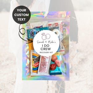 Puede incluir: Una bolsa transparente con cierre hermético iridiscente llena de artículos pequeños, incluyendo una menta, caramelos y paquetes. Una pegatina circular dice "Sarah & Mike's I DO CREW RECOVERY KIT". Un círculo negro encima de la bolsa dice "YOUR CUSTOM TEXT".
