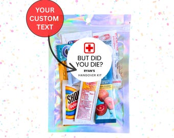 May include: A clear plastic bag filled with various small items, including a red and white striped straw, a small bottle of electrolyte drink mix, a packet of cherry flavoured drink mix, and a packet of wet wipes. The bag has a white circle with a red cross and the text "But did you die? Ryan's Hangover Kit" printed on it.