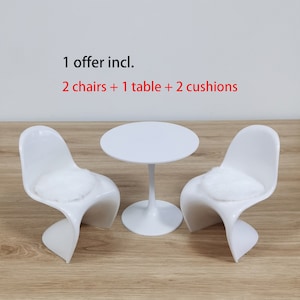 Puede incluir: Una mesa blanca y dos sillas blancas con cojines blancos. El texto "1 offer incl. 2 chairs + 1 table + 2 cushions" está por encima de los muebles.