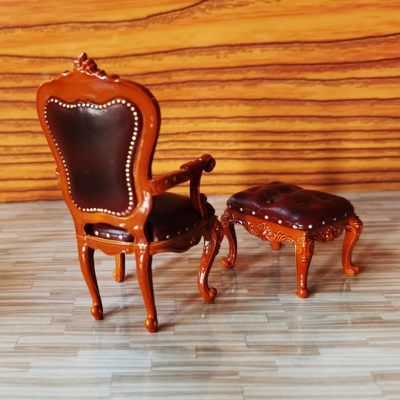 May include: A brown leather armchair with ornate wood carvings and a matching footstool. The chair and stool are both in a traditional style.