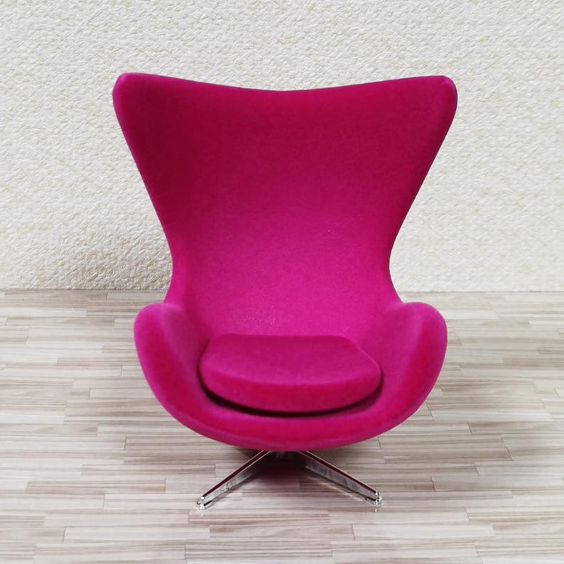 Pu&ograve; includere: Una sedia a forma di uovo di colore rosa brillante con una base girevole. La sedia &egrave; rivestita in un tessuto morbido e soffice.