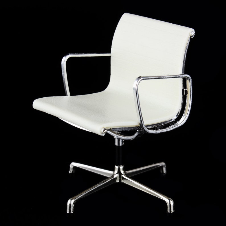 May include: A white office chair with a chrome frame and a swivel base. The chair has a padded seat and back.