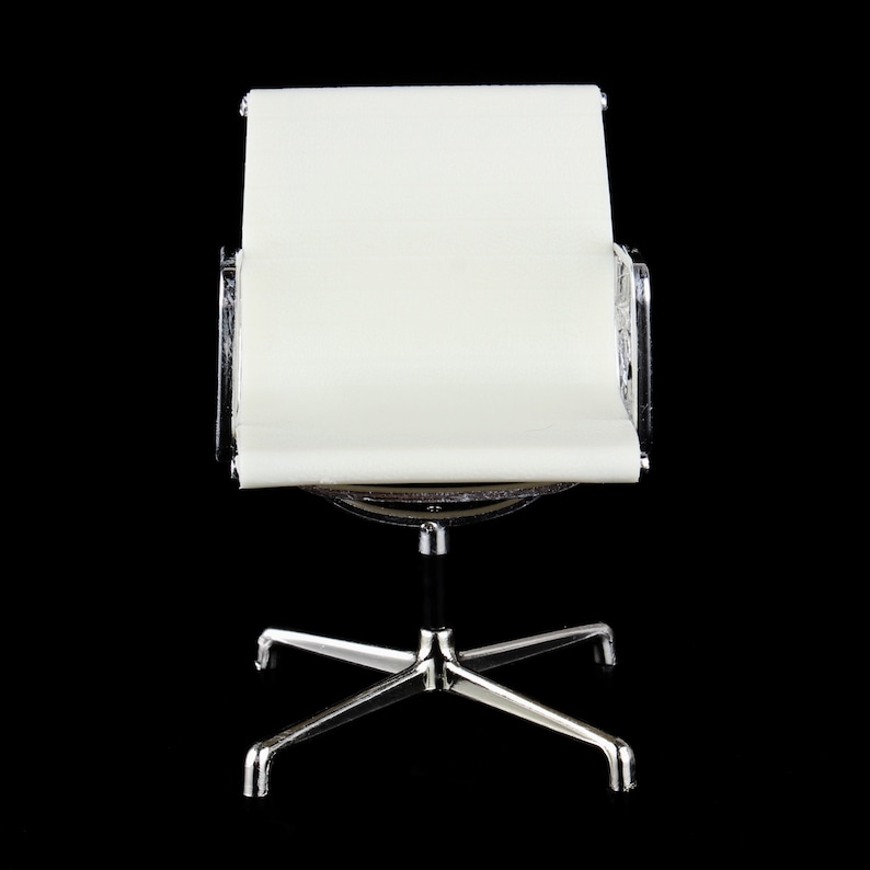 May include: A white chair with a chrome frame and a swivel base. The chair has a curved back and a comfortable seat.