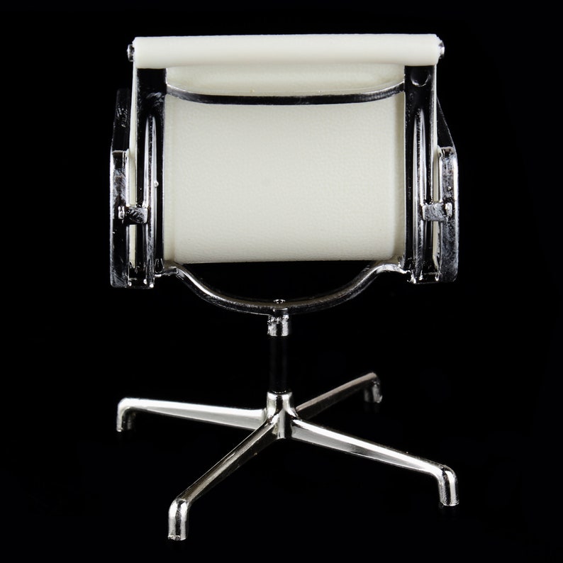 May include: A white office chair with a chrome frame and a star-shaped base. The chair is designed in a mid-century modern style.
