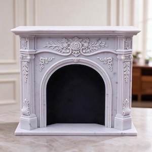 May include: A light grey marble-effect fireplace mantel featuring an arched opening with a black interior. The structure is decorated with intricate relief carvings of roses and scrolling foliage on the frieze and fluted columns on the sides.