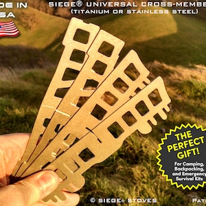 May include: Four gold-coloured metal pieces with cut-out designs, held in a hand. The pieces are labelled "SIEGER UNIVERSAL CROSS-MEMBERS (TITANIUM OR STAINLESS STEEL)". A starburst graphic reads "THE PERFECT GIFT!" with text below: "For Camping, Backpacking, and Emergency Survival Kits".
