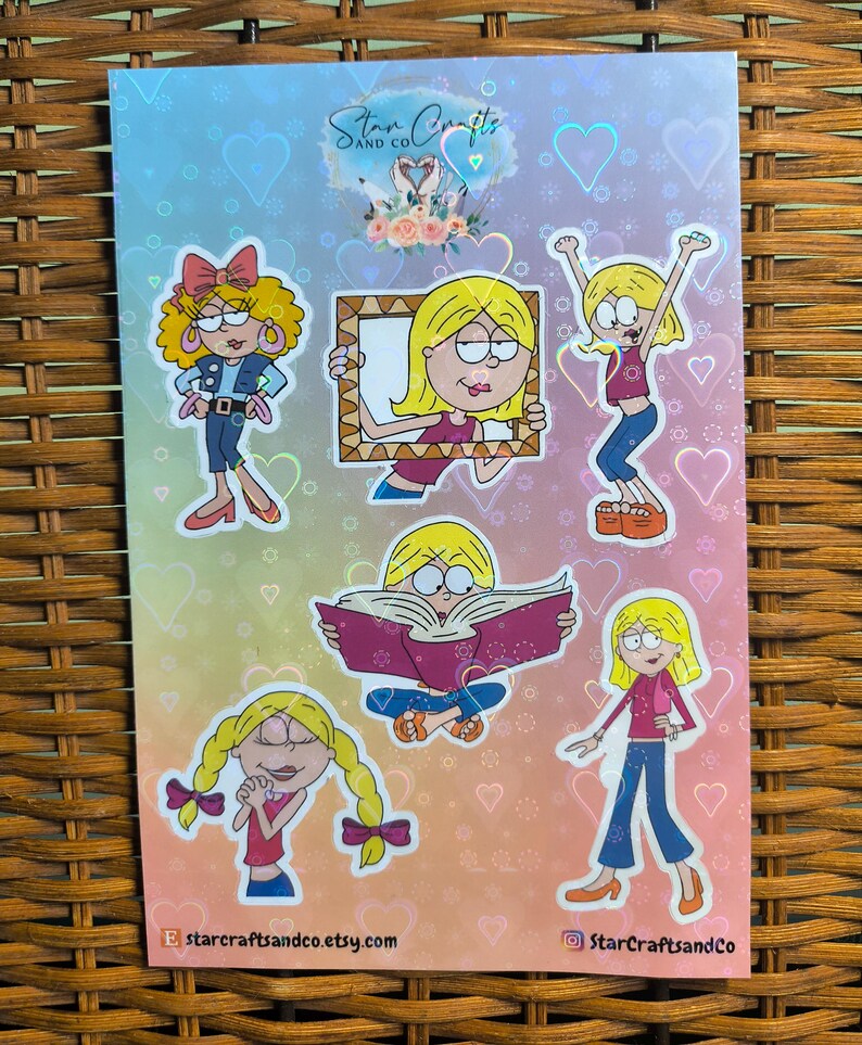 May include: A set of six holographic stickers featuring cartoon girls with different expressions and poses. The stickers are on a rainbow background with hearts. The text "Star Crafts and Co." is at the top of the sheet.