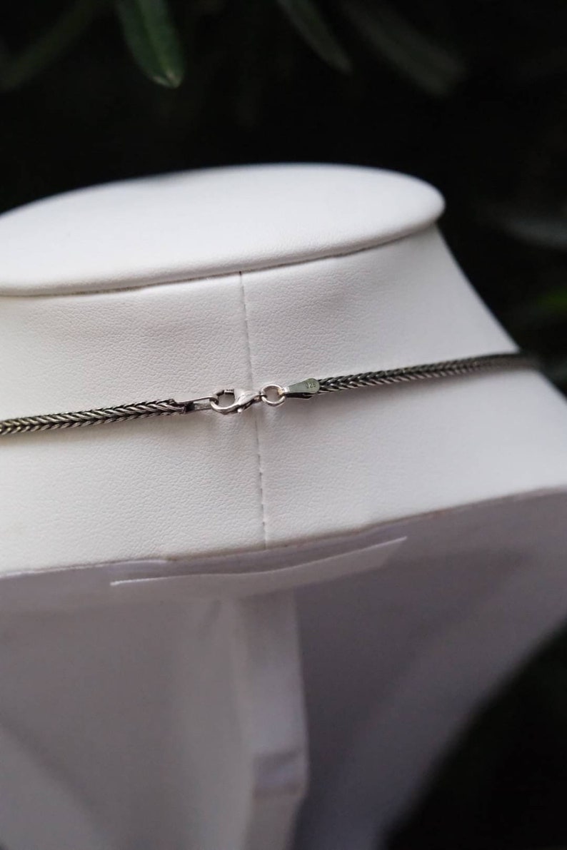 Puede incluir: Un collar de cadena de plata con cierre de mosquet&oacute;n. La cadena est&aacute; hecha de peque&ntilde;os anillos unidos.