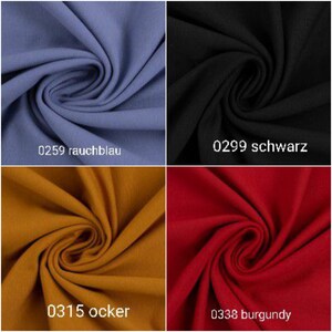 Puede incluir: Cuatro muestras de tela en diferentes colores: azul ahumado, negro, amarillo mostaza y burdeos. La tela est&aacute; doblada en forma de espiral. Las muestras est&aacute;n etiquetadas con n&uacute;meros y nombres de colores: 0259 rauchblau, 0299 schwarz, 0315 ocker, 0338 burgundy.