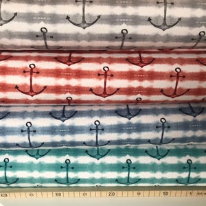 May include: Four rolls of fabric with a white background and a repeating pattern of navy blue anchors and watercolor stripes in shades of gray, red, blue, and green.