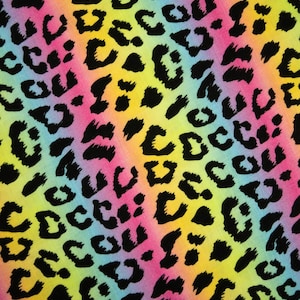 Könnte beinhalten: Ein farbenfrohes Textil mit Leopardenmuster. Das Muster zeigt schwarze Flecken auf einem Farbverlaufshintergrund aus Rosa, Gelb und Blau, wodurch ein auffälliges und auffälliges Erscheinungsbild entsteht.