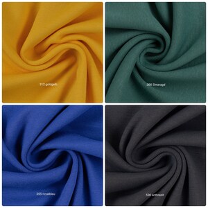 Puede incluir: Cuatro muestras de tela en diferentes colores: dorado, verde, azul y gris. Las muestras est&aacute;n dobladas y muestran la textura de la tela.