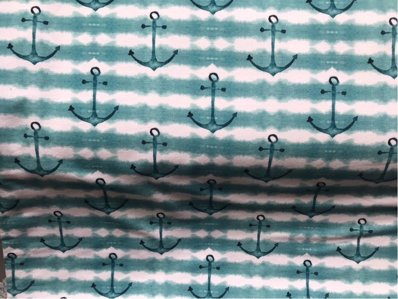 May include: A teal and white fabric with a repeating pattern of anchors. The anchors are a dark teal color and are set against a white background with teal stripes.
