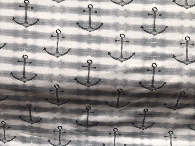 May include: A white and gray fabric with a repeating pattern of black anchor designs. The anchors are stylized and have a watercolor effect.