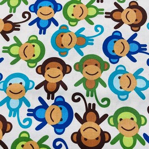 Könnte beinhalten: Ein weißer Stoff mit einem sich wiederholenden Muster aus Affen in verschiedenen Farben, darunter Blau, Grün, Braun und Orange. Die Affen lächeln alle und haben unterschiedliche Gesichtsausdrücke.