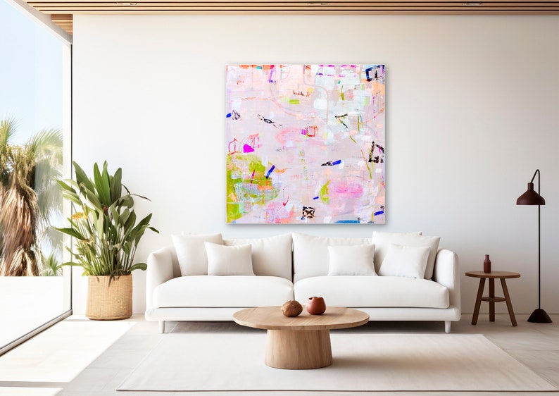 Peut inclure: Peinture abstraite aux couleurs rose, verte, bleue et blanche. La peinture est sur une toile blanche et est accroch&eacute;e &agrave; un mur blanc dans un salon.