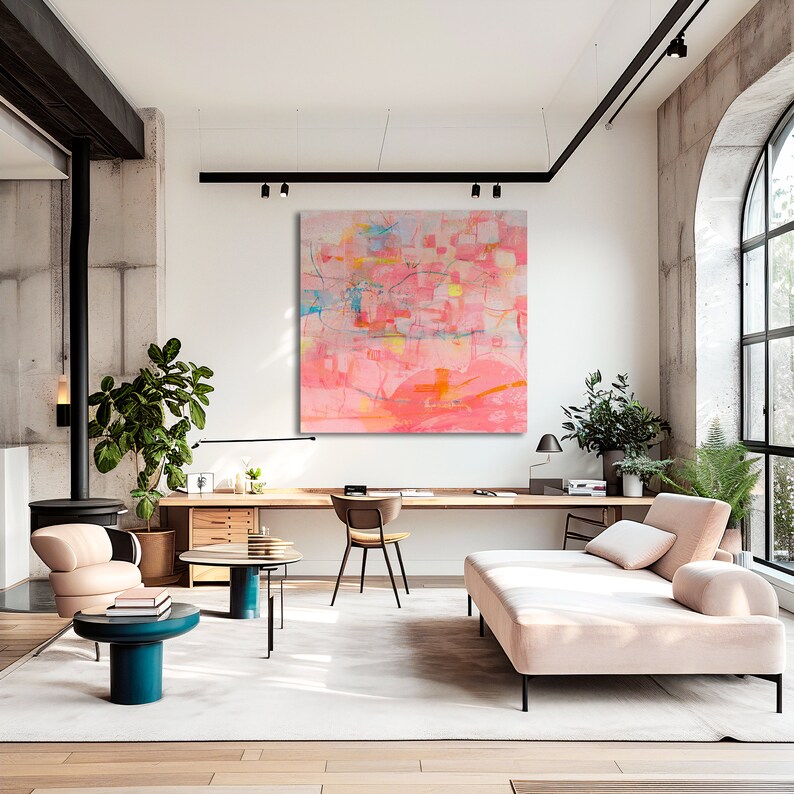 May include: Abstract painting in shades of pink, orange, and yellow with geometric shapes and lines. The painting is hanging on a white wall in a modern living room with a couch, coffee table, and plants.