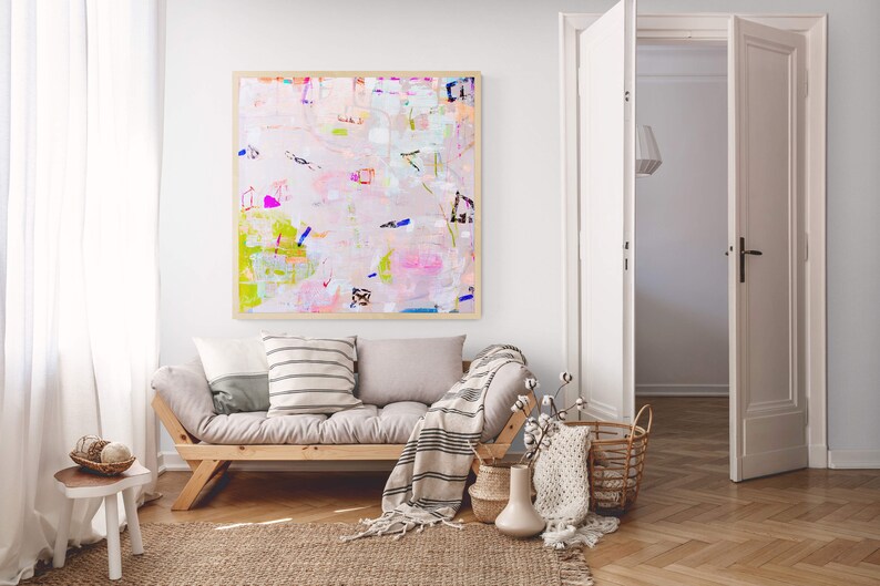 Peut inclure: Un canap&eacute; gris clair avec une couverture ray&eacute;e et deux coussins. Un tableau abstrait encadr&eacute; avec des couleurs rose, verte et bleue est accroch&eacute; au mur derri&egrave;re le canap&eacute;.