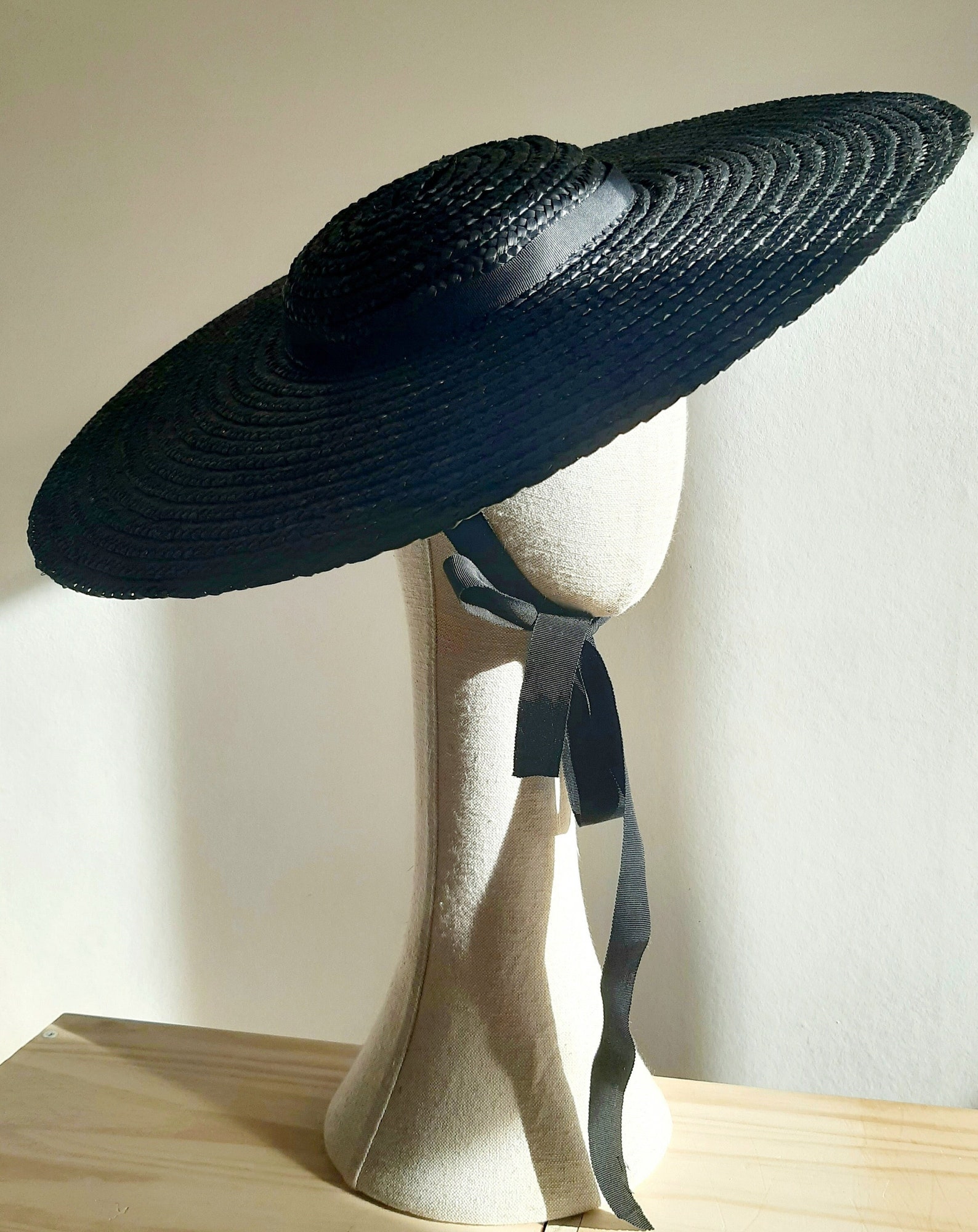 Black wide-brim straw hat with ribbon tie, ideal for summer goth outfits or vintage-inspired beach ensembles.