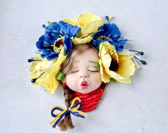 Decoration with silk flowers.Flag of Ukraine.Ukrainian woman with a wreath on her head.Brooch Ukraine.Brooch with floral decor.