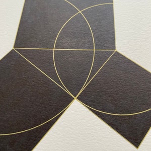 May include: A geometric abstract art print with a black background and gold lines forming a square shape with a circle inside. The circle is partially cut off by the edges of the square. The square is divided into four sections by two lines that intersect in the center of the square. The lines are also partially cut off by the edges of the square.