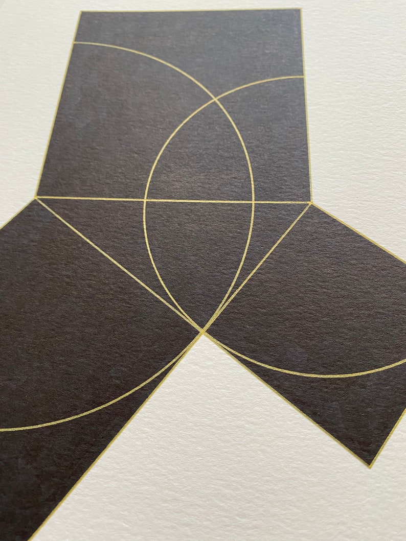 May include: A geometric abstract art print with a black background and gold lines forming a square shape with a circle inside. The circle is partially cut off by the edges of the square. The square is divided into four sections by two lines that intersect in the center of the square. The lines are also partially cut off by the edges of the square.