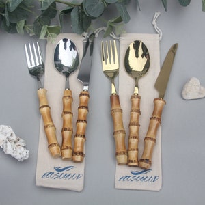 Cutlery set with steel ends and a handle made from real bamboo pieces with nodes. Set consists of 3 pieces and the ends are either gold or silver. They come with an Ecosogood branded drawstring pouch. Photographed with leaves & white stones