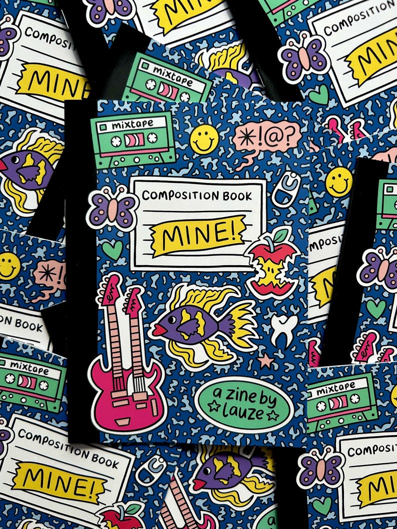 May include: A composition book with a blue background covered in colorful stickers. Stickers include a pink guitar, fish, butterflies, cassette tapes, and the text "MINE!". The phrase "a zine by Lauze" is also visible.