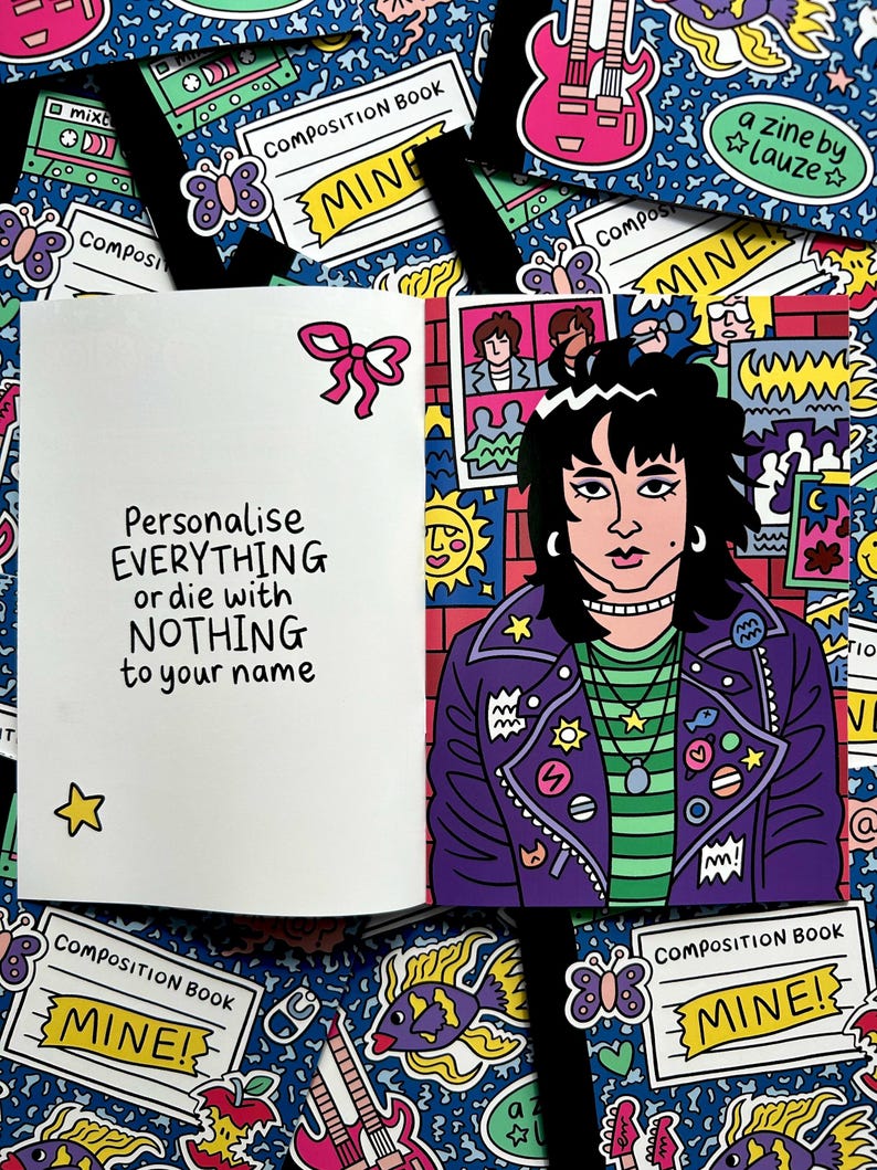 May include: An open notebook with the text "Personalise EVERYTHING or die with NOTHING to your name" and a cartoon illustration of a person wearing a purple jacket. The background is a blue pattern with various stickers.