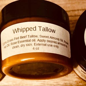 May include: Three jars of whipped tallow skincare product. The jars have black lids and white labels with the product name and ingredients. The jars are 113 grams each.