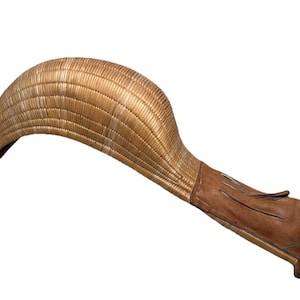 May include: A vintage jai alai cesta, featuring a woven basket-like head and a leather-wrapped handle. The cesta is made of natural-colored materials, with a curved shape and a brown leather grip.