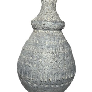 May include: A gray ceramic lamp base with a textured surface and a decorative pattern of small circles and vertical lines. The lamp base has a bulbous shape with a narrower neck and a metal rod at the top.