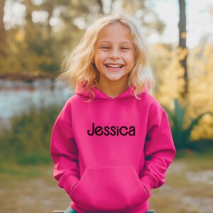 May include: A bright pink hooded sweatshirt with the name "Jessica" printed in black on the front.