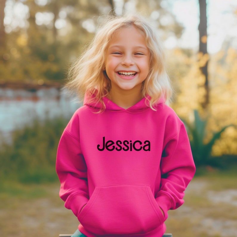 May include: A bright pink hooded sweatshirt with the name "Jessica" printed in black on the front.