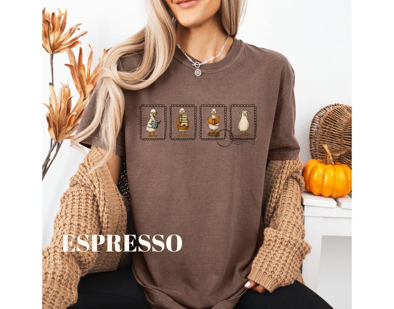 May include: Espresso-colored t-shirt featuring four postage stamp designs with cartoon ducks. The stamps depict ducks with books, a teapot, and a hat. The word "ESPRESSO" is printed in large white letters at the bottom of the shirt.