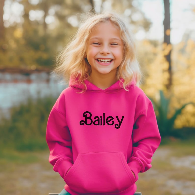 May include: A pink hooded sweatshirt with the name "Bailey" in a black, stylized font on the front.