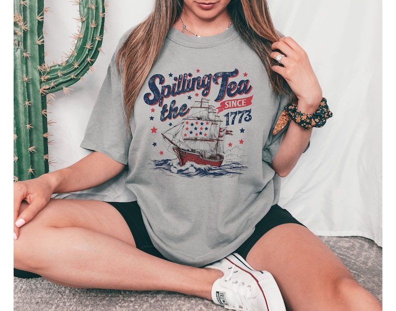 May include: A gray t-shirt with a vintage-style graphic of a ship and the text "Spilling Tea Since 1773".