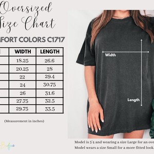 May include: A size chart for oversized Comfort Colors C1717 t-shirts. The chart shows sizes S to 4XL with width measurements from 46.35 to 75.57 cm and lengths from 67.56 to 85.09 cm. A model is wearing a size Large.