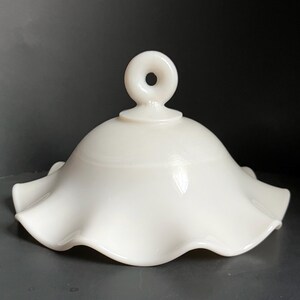 May include: White milk glass lampshade with a ruffled edge and a ring handle on top.