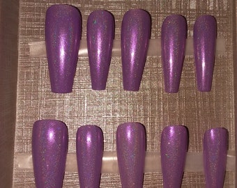 May include: Ten purple coffin-shaped press-on nails with a glittery finish.