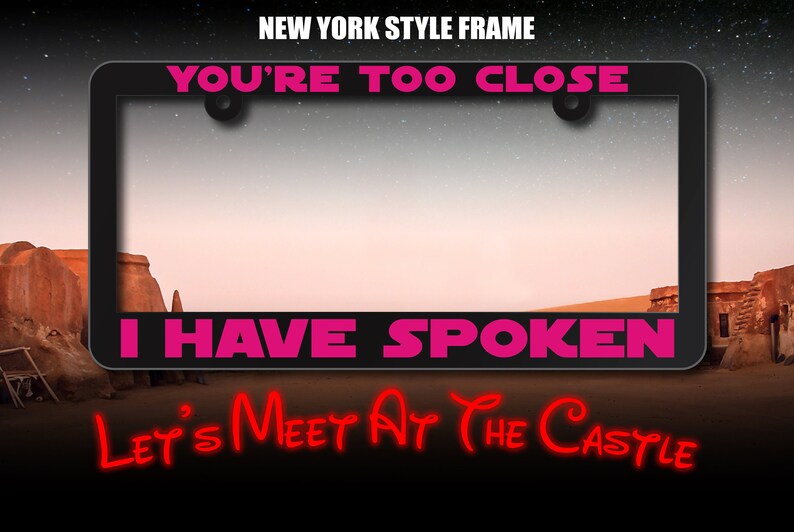 May include: A black license plate frame with the text "YOU'RE TOO CLOSE I HAVE SPOKEN" in pink lettering. Below the frame is the text "LET'S MEET AT THE CASTLE" in red lettering.