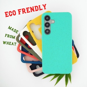 Op de afbeelding: Een stapel telefoonhoesjes in diverse kleuren waaronder turquoise, geel, olijfgroen, rood, blauw, roze en zwart, met een gespikkelde textuur. De tekst ECO FRENDLY MADE FROM WHEAT is zichtbaar. Het bovenste turquoise hoesje toont drie cameralenzen.