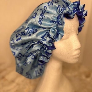 May include: A light blue satin bonnet with a blue and white print that says "Let's Get Juicy".