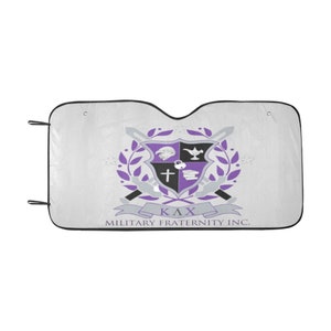 May include: White car sunshade with a black border and a purple and gray crest design. The crest includes a shield, swords, and the text "ΚΛΧ MILITARY FRATERNITY INC."